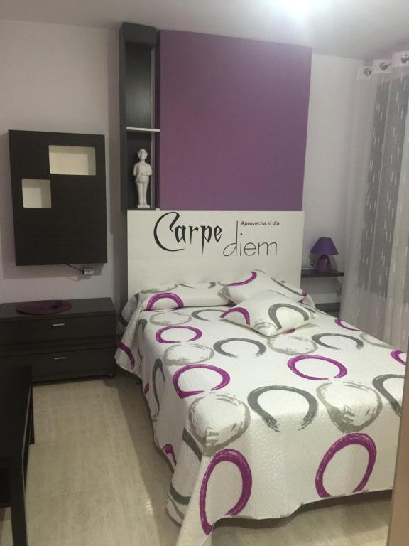 1 dormitorio con 1 cama con pared morada en SilvantColors Atic, en Benicarló