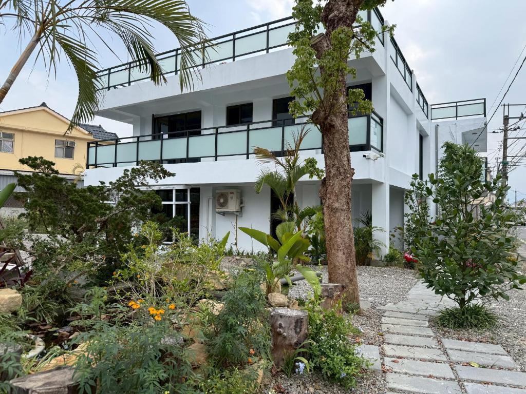 a white house with a garden in front of it at Shin Mei B&B in Puli