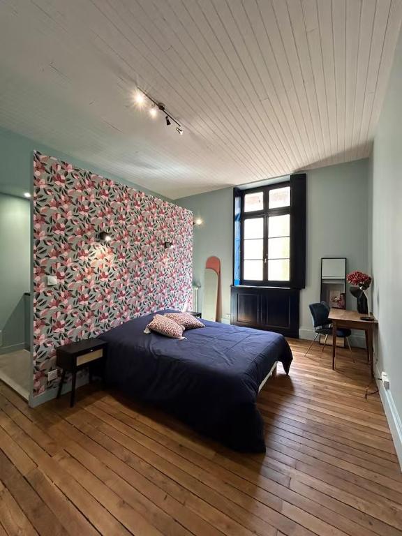 a bedroom with a large bed and a large wall at Escales patrimoniales en cœur de ville in Poitiers
