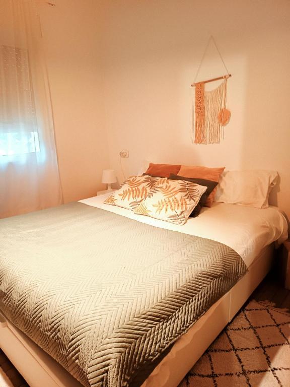 a bedroom with a large bed with white sheets at SWEET HOME BILBAO in Bilbao