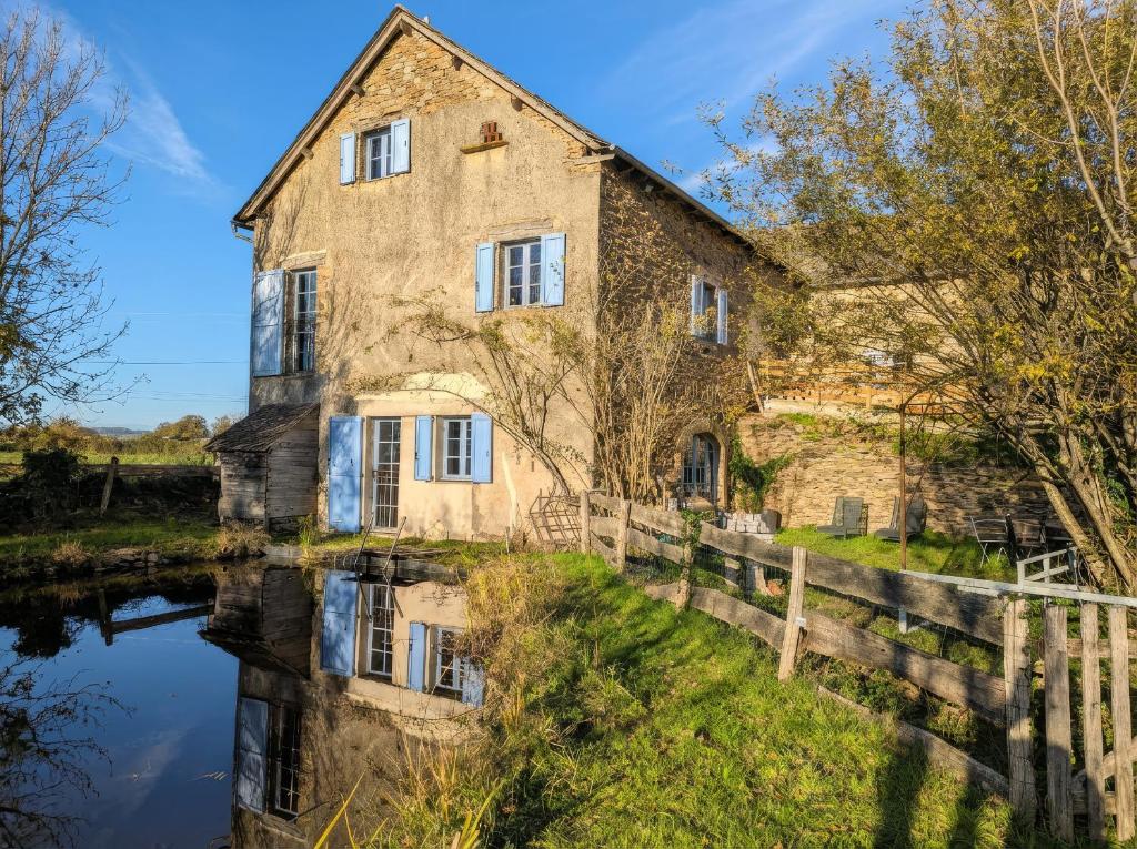 ein altes Steinhaus neben einem Fluss in der Unterkunft Saisonnée - Chambres d'Hôtes et Table d'Hôtes en Aveyron in Centrès