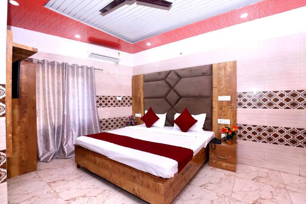 a bedroom with a large bed with red pillows at Hotel S2 Residency Near Railway Station Chandigarh in Chandīgarh