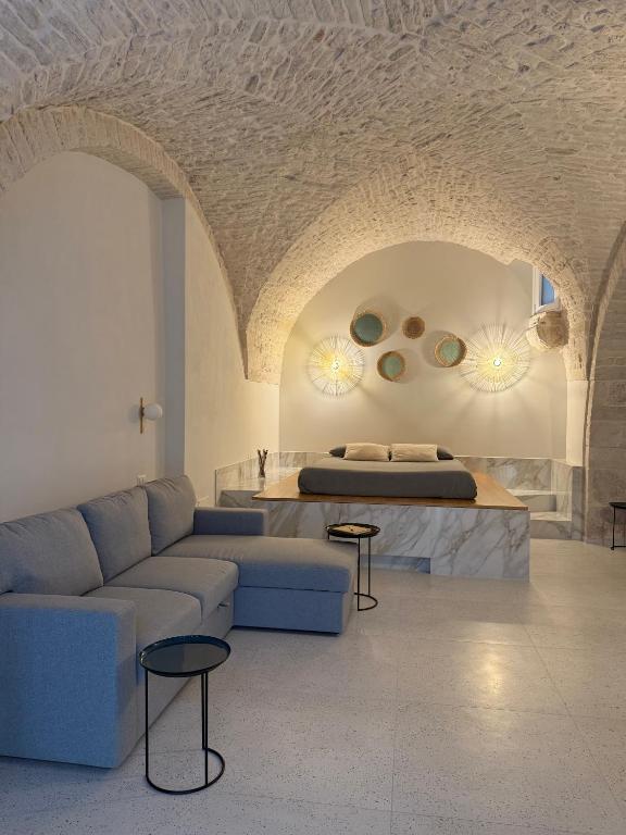 ein Wohnzimmer mit Sofa und Bett in der Unterkunft Avril Suite in Noci