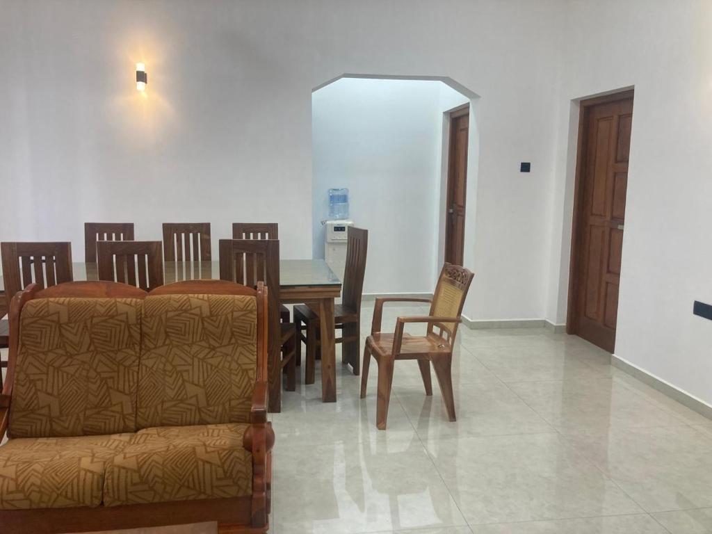 a dining room with a couch and a table and chairs at Siva Residencies in Wattala