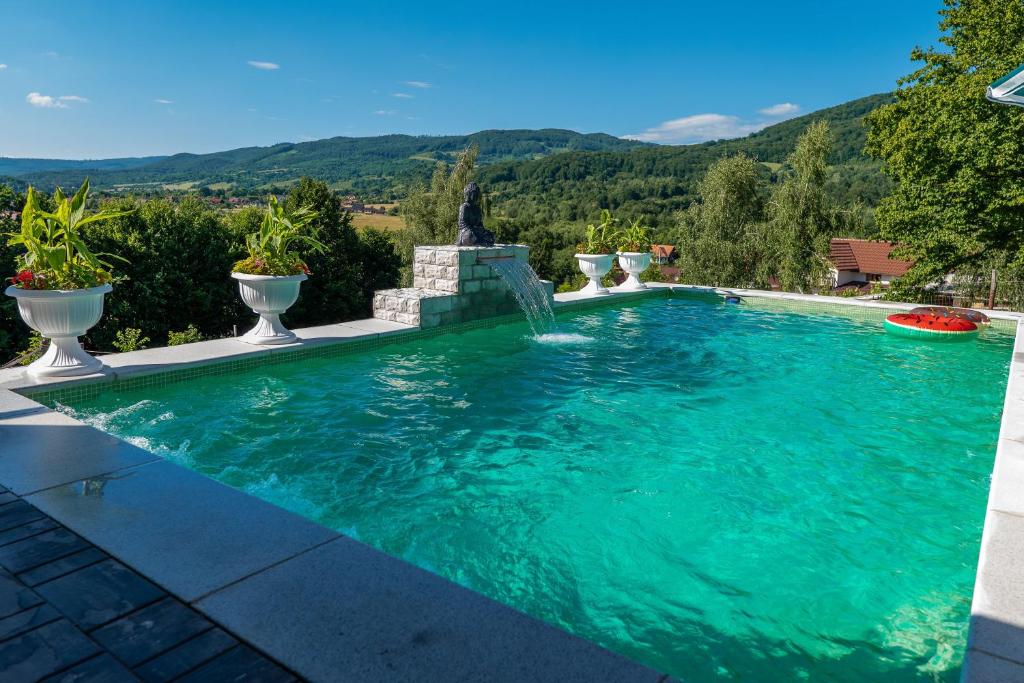 a swimming pool with a waterfall and a fountain at Villa Panoramic Sovata in Sovata