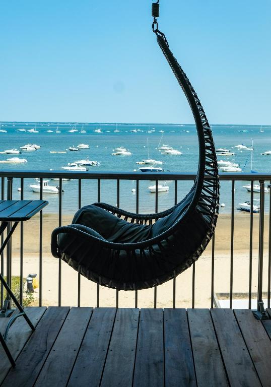 a hammock on a deck with a view of the beach at Duplex Cocon & Vue Mer Imprenable in Arcachon