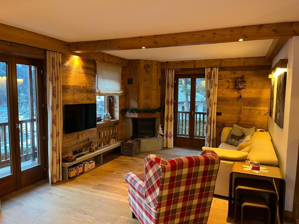 a living room with a couch and a tv at L'Atelier du Temps - Chalet Crammont in Courmayeur