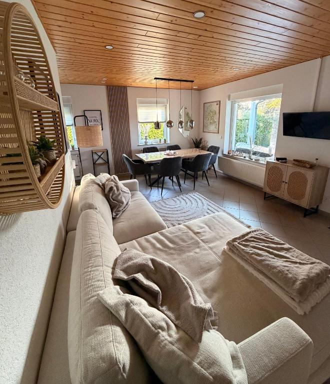 a living room with a couch and a dining room at ZweiundMeer Bungalow 1 in Wiek auf Rügen
