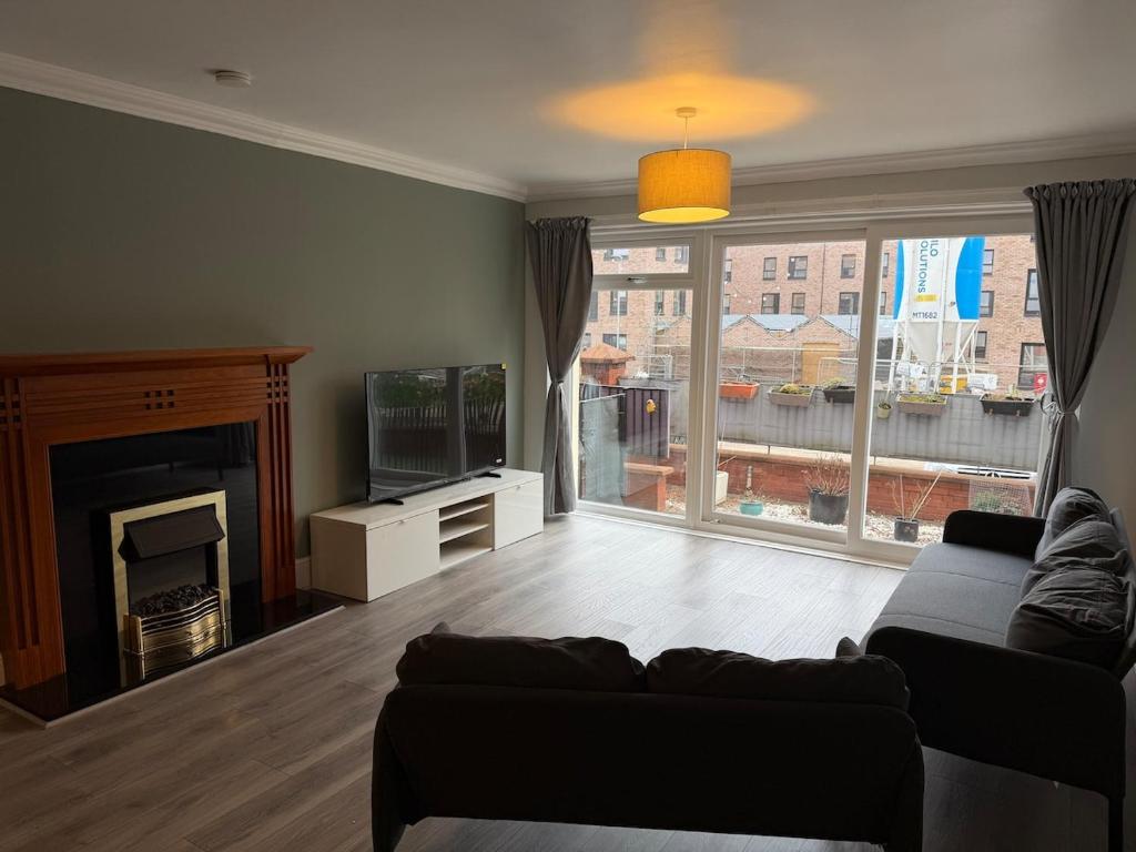 a living room with a couch and a fireplace at Spacious Glasgow Group Stay in Glasgow
