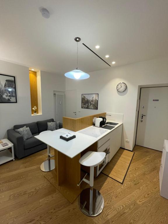 a kitchen and living room with a table and a couch at Torino48 Studio Apartment in Milan