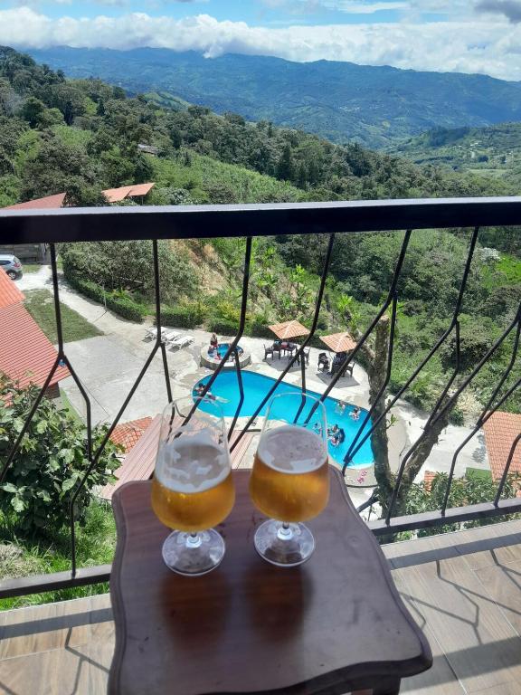 two glasses of beer sitting on a table with a view at Suite relax entre naturaleza y piscina en Tulipe in El Porvenir
