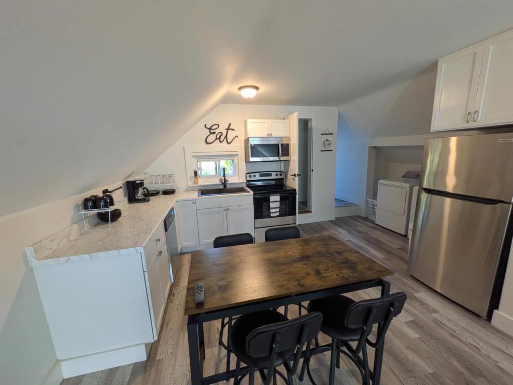 a kitchen with white cabinets and a table and chairs at Apartment 1 in Rockingham