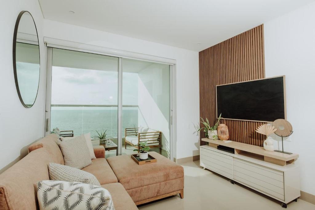 a living room with a couch and a flat screen tv at Beachfront 2BR Luxury Living Walk Everywhere in Cartagena de Indias