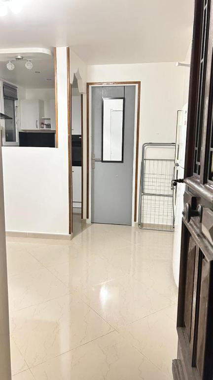 Studio duplex Meublé في شيربوغ أون كوتننتين: غرفة فارغة بها باب ومطبخ