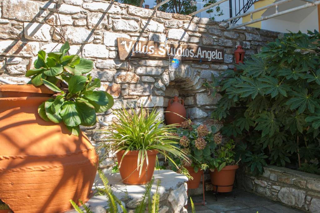 a stone wall with plants and a sign on it at Angela studios in Troulos