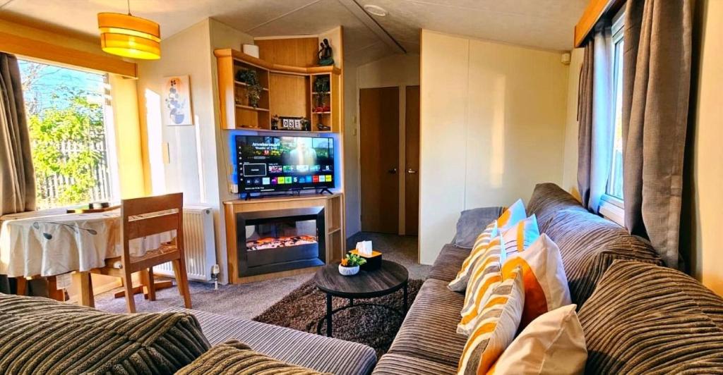 a living room with a couch and a television at Caravan in Clacton-on-Sea in Little Clacton