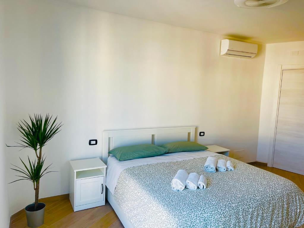 a bedroom with a bed with three pillows on it at La Loggia sui Giardini in Mola di Bari