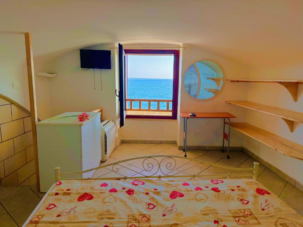 a bedroom with a bed with a view of the ocean at Perla Sul Mare in Gallipoli