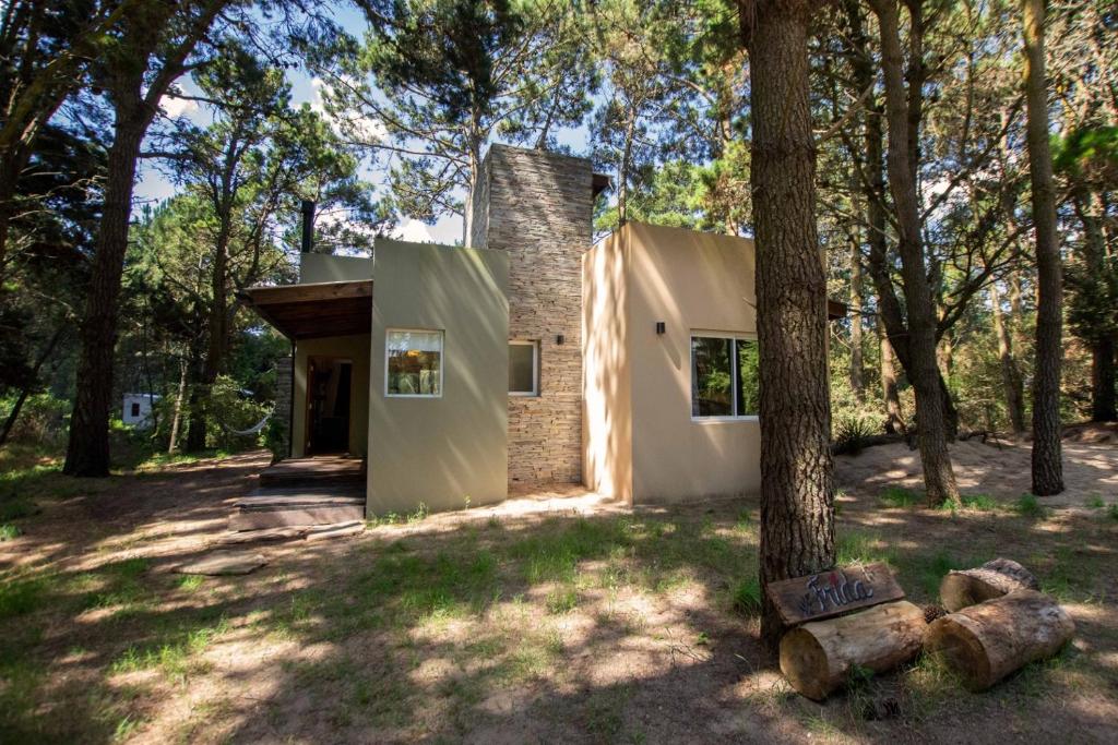 a house in the woods with a tree at Casa Frida vivir sin prisa in Mar de las Pampas