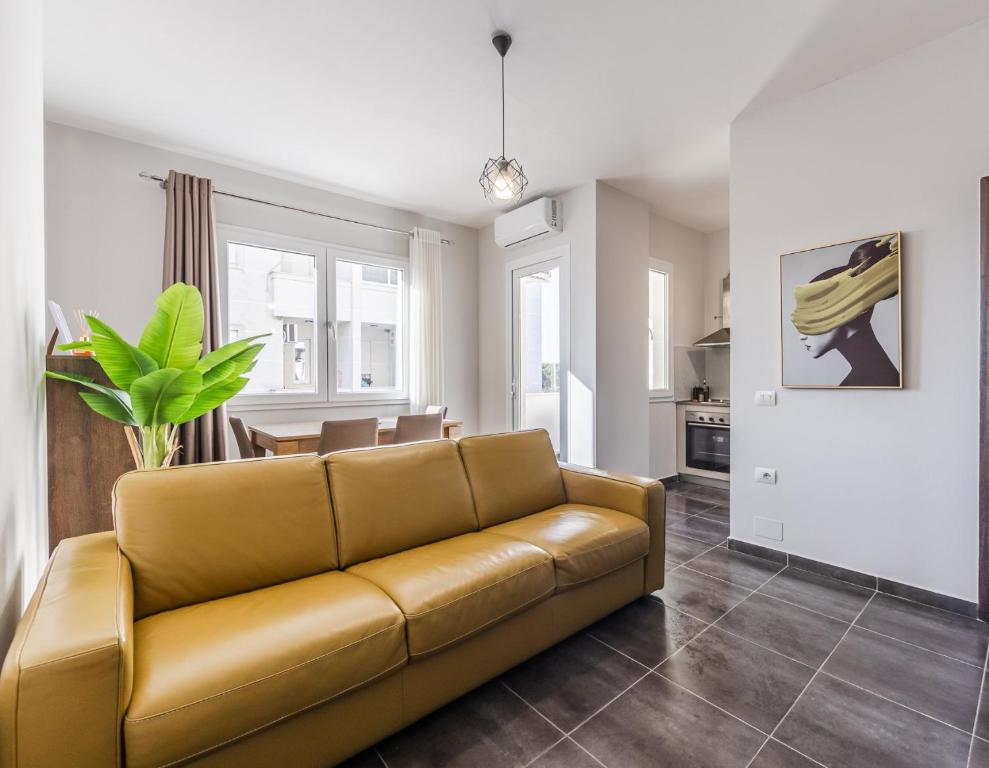 a living room with a couch and a dining room at The Seabreeze Apartment by PikHost in Lalzit Bay