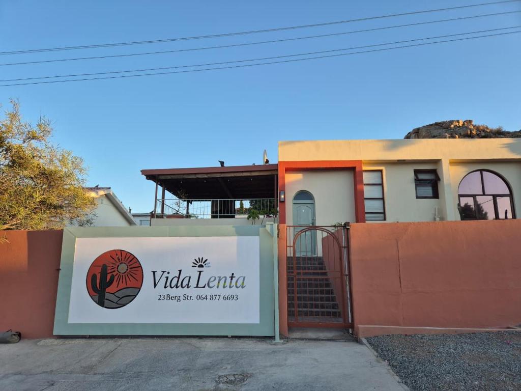 a sign in front of a house with a gate at Vida Lenta in Springbok