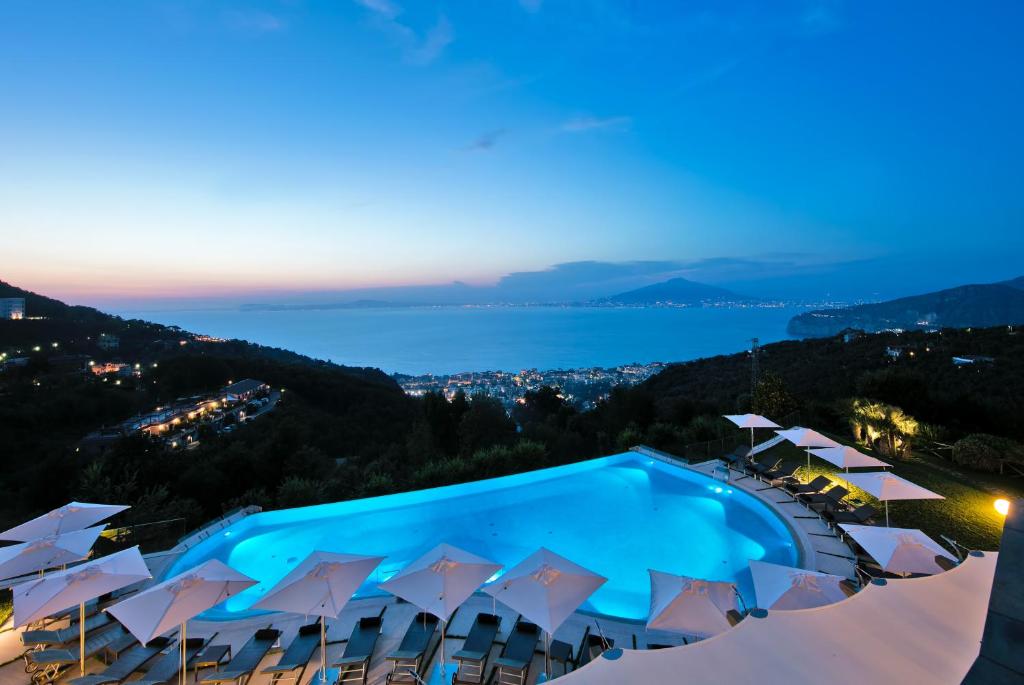 vista su una piscina con ombrelloni e un resort di Due Golfi Grand Hotel a SantʼAgata sui Due Golfi
