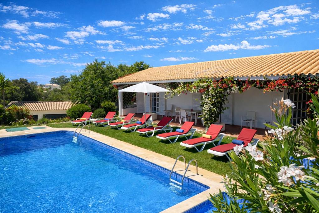 a swimming pool with lounge chairs and a house at Espraguina - Private Pool - 16 Guests - Loulé in Loulé