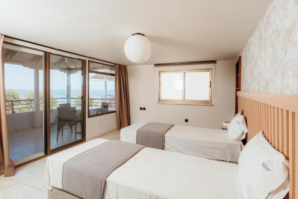 a hotel room with two beds and a balcony at Aqua Beachfront Elegant Hotel in Olympic Beach