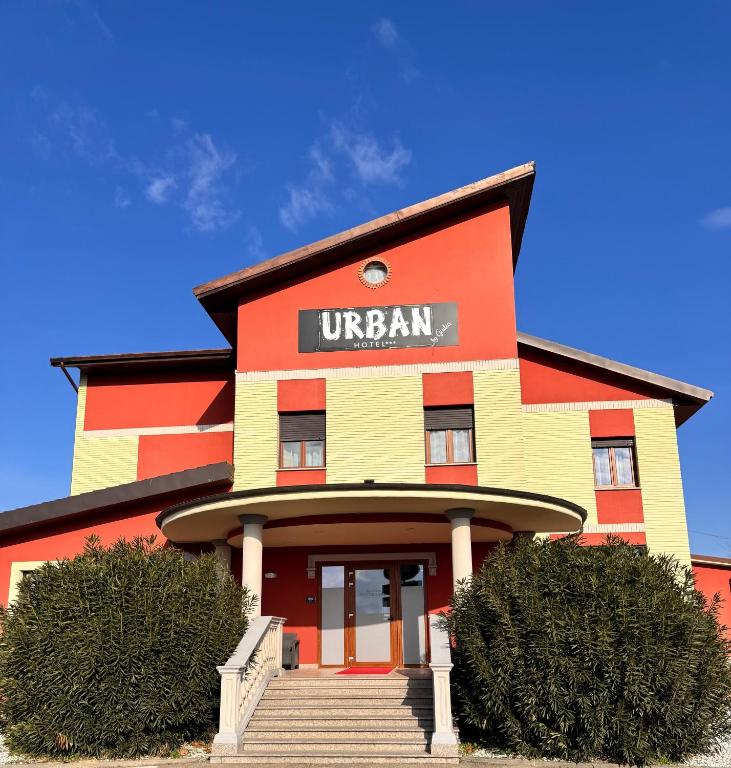 a orange yellow and red building with a sign on it at Hotel Urban By Giulia in Pozzolo Formigaro