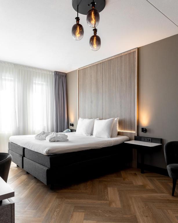 a bedroom with a large bed and a large window at HOTEL ALKMAAR - Bar & Restaurant - Meeting & Events in Alkmaar