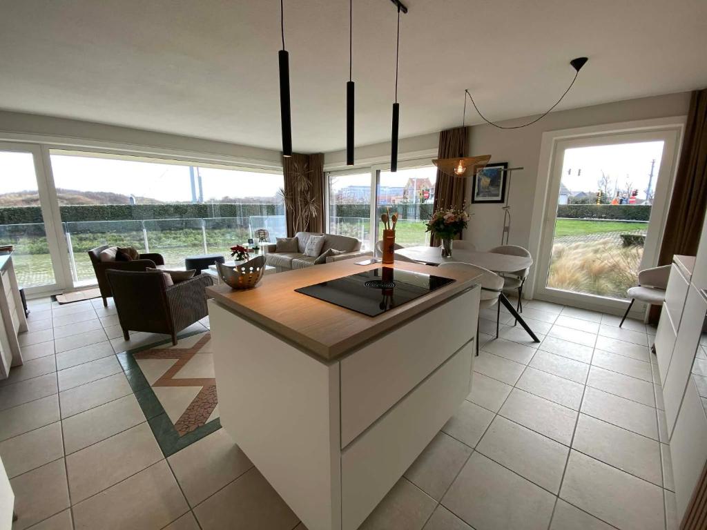 a kitchen and living room with a table and chairs at SunnySide-of-TheSea - stunning view on nature, big terraces all around - 150 m from sea, beach, stores, restaurants & beach bars - with parking in Nieuwpoort