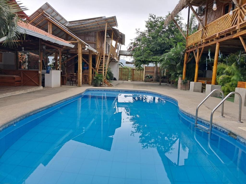 ein Pool in einem Resort mit blauem Wasser in der Unterkunft HostalElCascolManabiPuertolopez in Puerto López