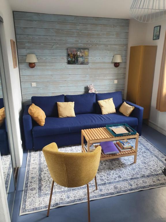 a living room with a blue couch and a coffee table at Appartement avec balcon et vue sur les montagnes in Bielle