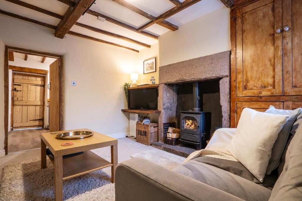 a living room with a couch and a fireplace at Mill Workers Cottage in Cromford