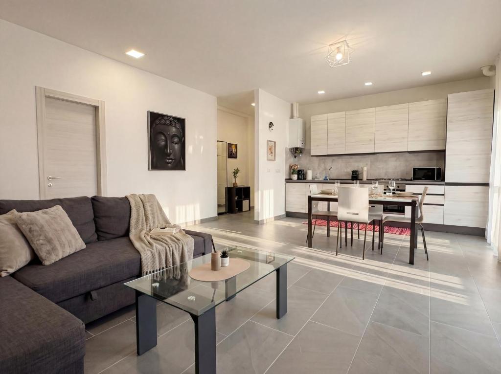 a living room with a couch and a table at Suite Prisma - Modern & Spacious Apartment near Verona Fair in Verona