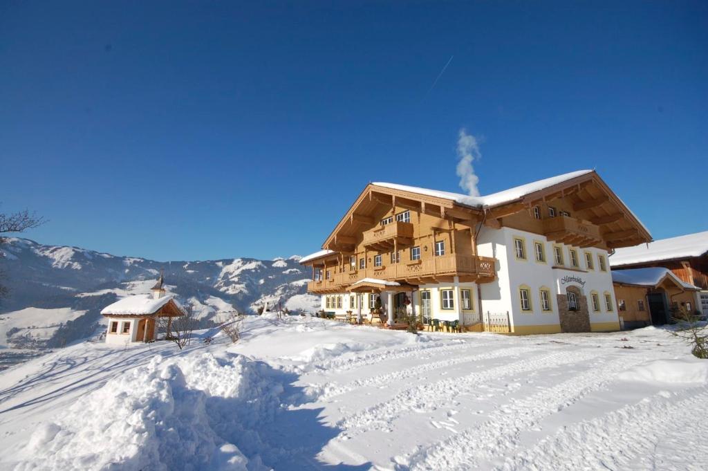 a large building on top of a snow covered mountain at Mitterbichlhof in Sankt Johann im Pongau