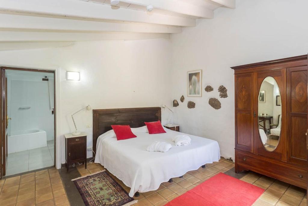a bedroom with a white bed with red pillows at GuestReady - Hotel Rural Las Calas in Vega de San Mateo