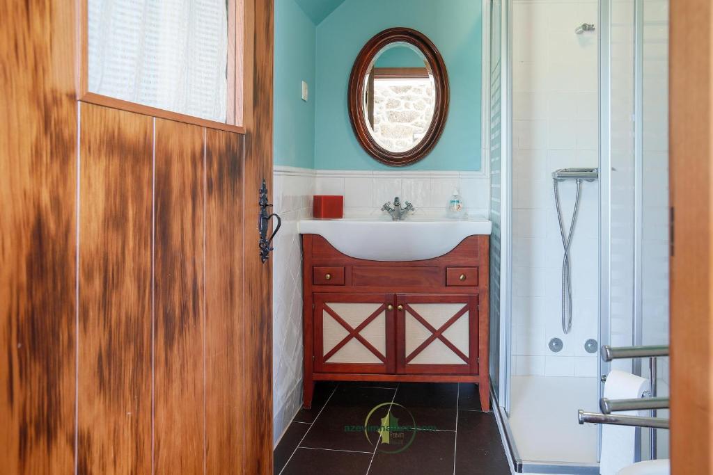 a bathroom with a sink and a mirror at Casa Cabreiros de Baixo in Melgaço