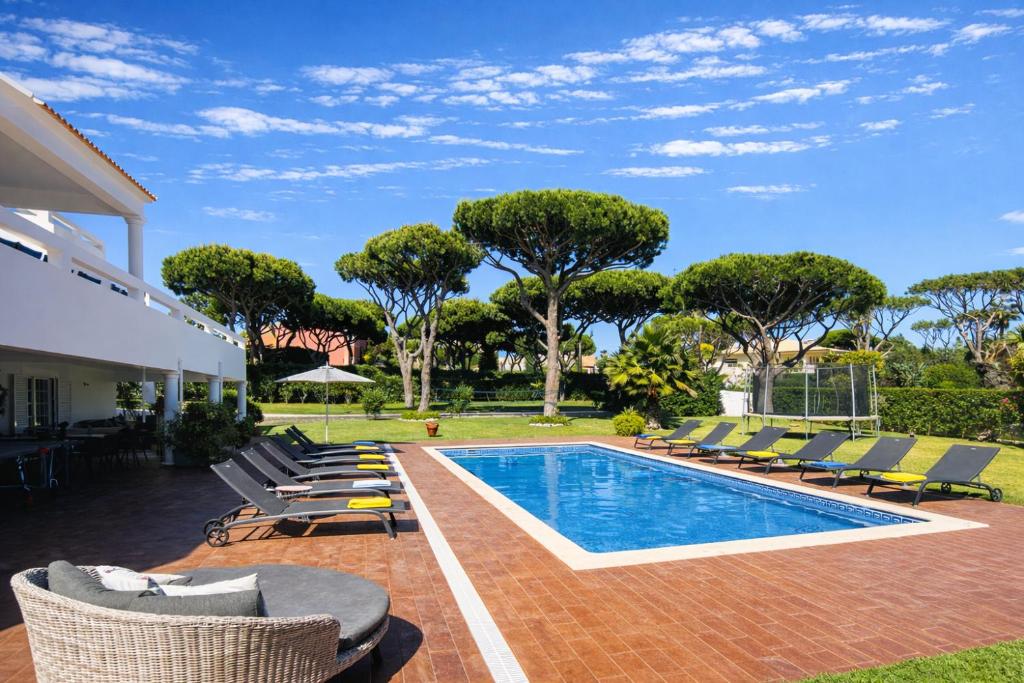 a swimming pool with lounge chairs next to a house at Fonte Santa - Private Pool - 14 Guests - Quarteira in Quarteira