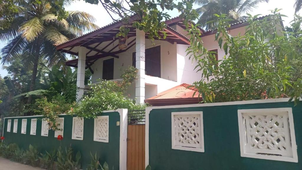 a house with a green and white fence at Ranga's house in Minuwangoda