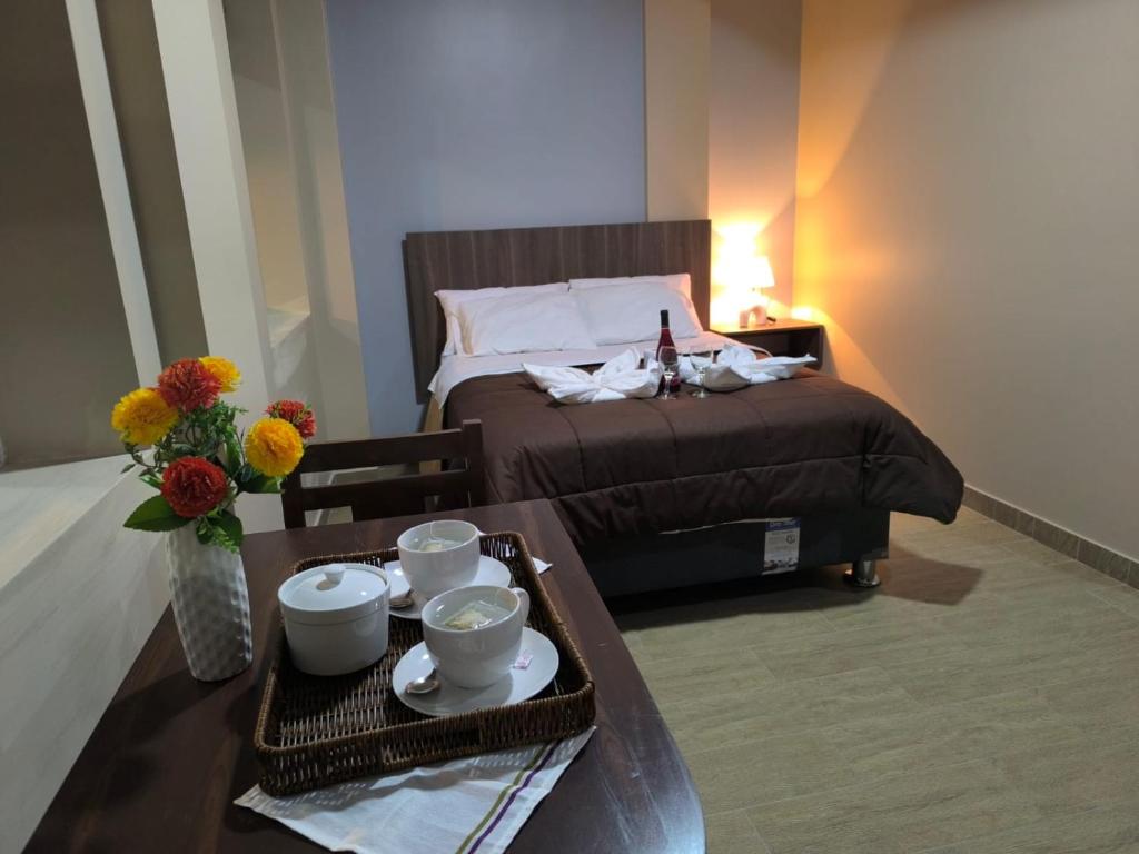 a bedroom with a bed and a table with a tray of food at Hotel Ayacucho in San Antonio