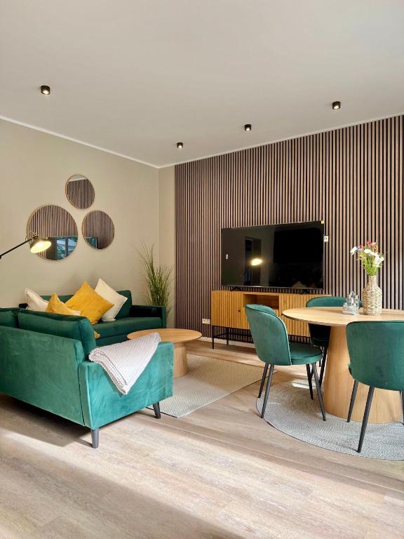 a living room with a green couch and a table at Lichtdurchflutetes Design-Apartment U39-1 in Niederdorla