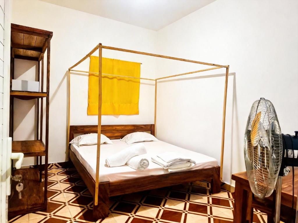 a bedroom with a bed with a canopy at Bee Rooms Nosy be in Ambatoloaka