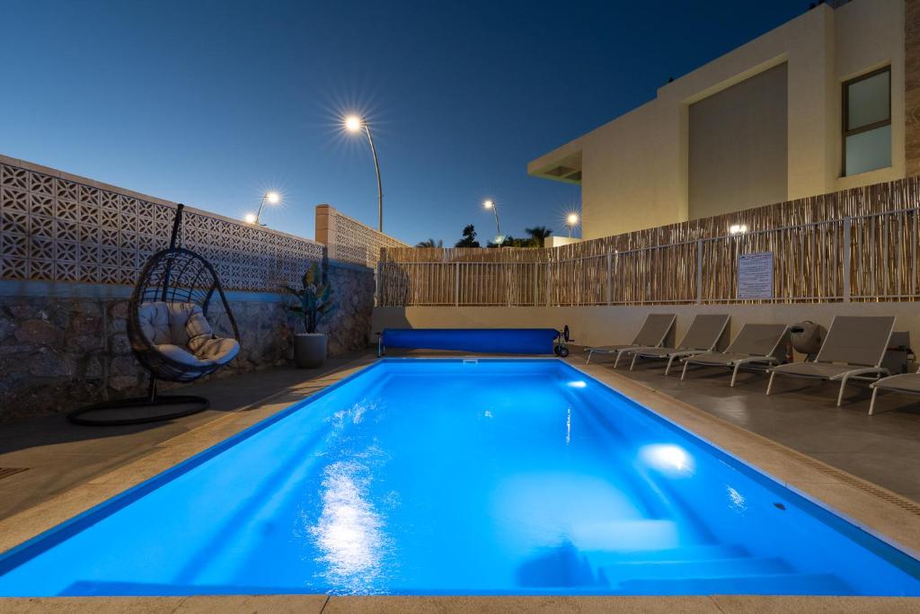 a swimming pool at night with chairs around it at וילה אקווה סול DreamyRent Villa Aqua Sol in Eilat