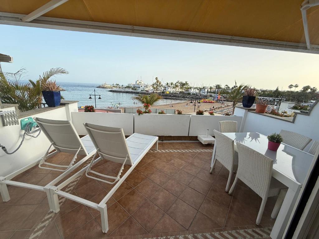 a balcony with a table and chairs and a view of the ocean at Mogán suite in Puerto de Mogán