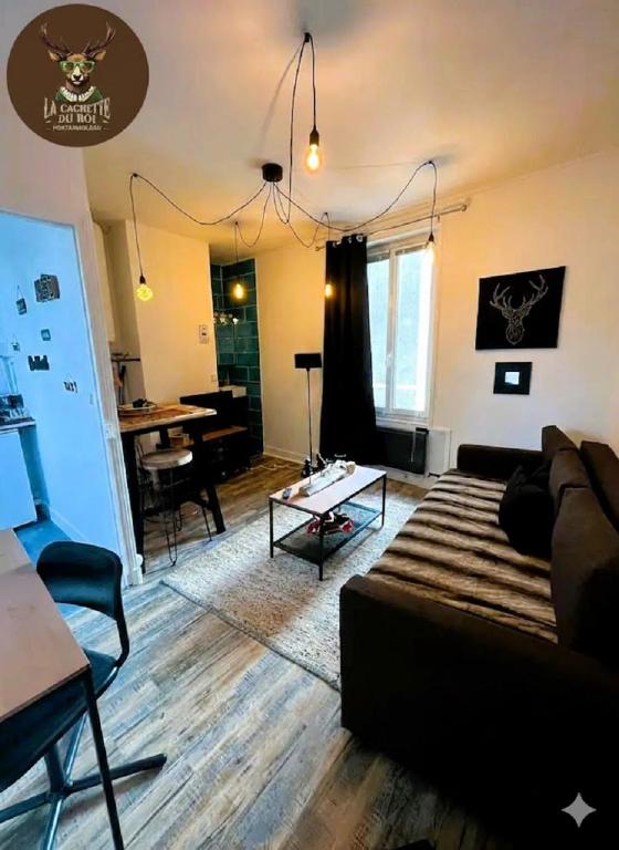 a living room with a couch and a table at La Cachette du Roi in Fontainebleau