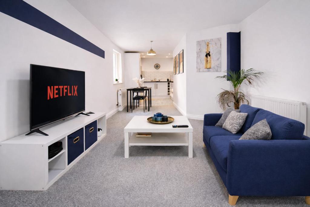 a living room with a blue couch and a tv at Poets Court in West Bromwich