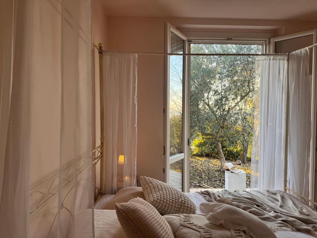 a bedroom with a bed and a large window at Dimora dei Passi Lenti in Montegranaro
