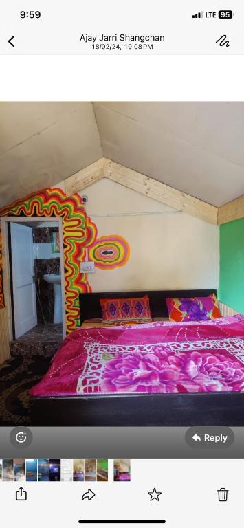 a bedroom with a bed with a colorful comforter at Classic hostel in Katra