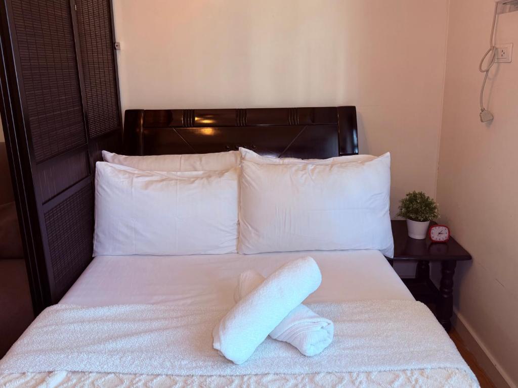 a pillow laying on a bed with white sheets at Cozy Condo in Ermita Manila near St Lukes Medical Center and US Embassy in Manila